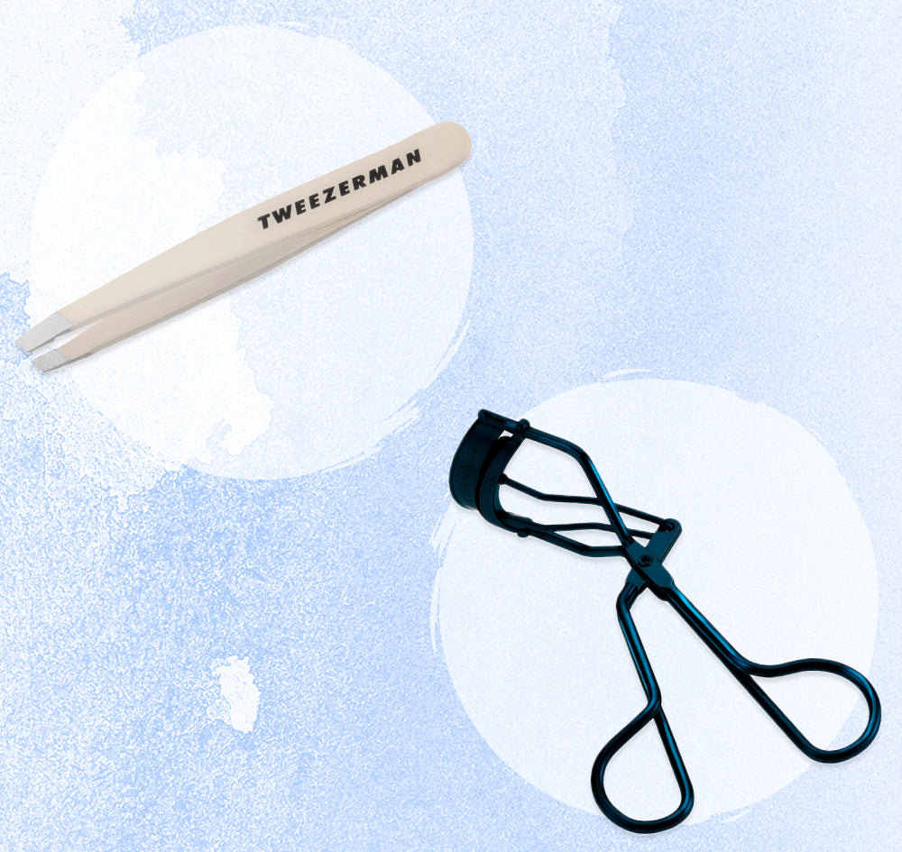 Tweezerman nude color tweezers and navy eyelash curler on a light blue background