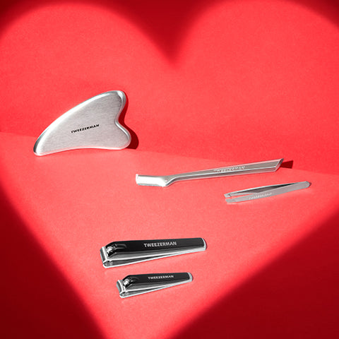 Red background with heart shadow, stainless teel gua sha, brow razor, mini slant, black combo clipper