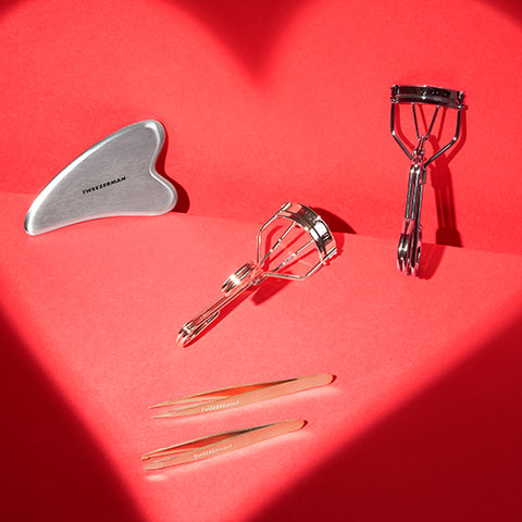 Red background with heart shadow, stainless steel gua sha, pro curler eyelash curler, pro master black eyelash curler, rose gold slant and point tweezers
