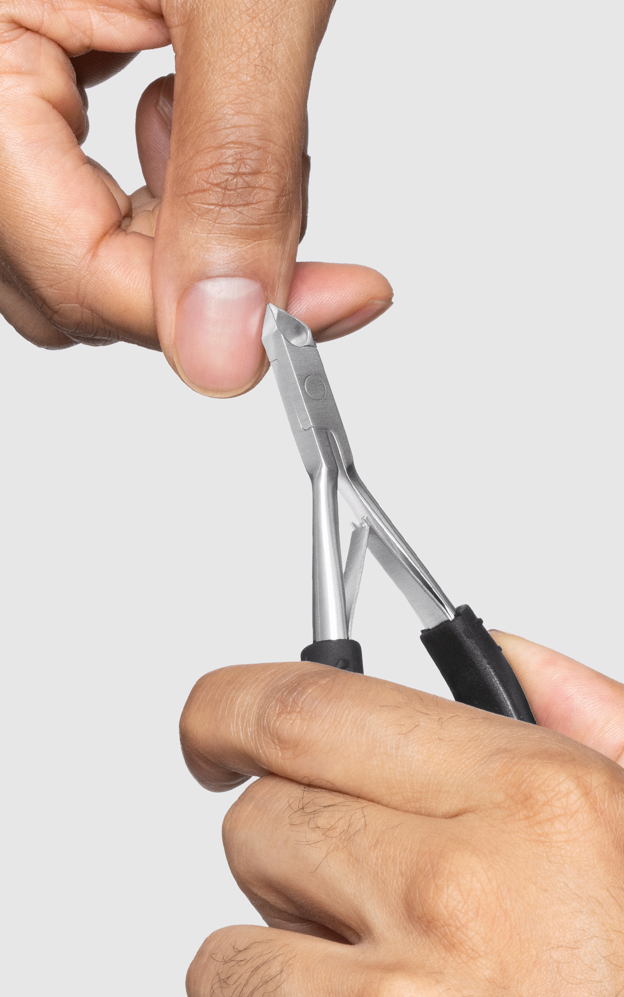 MALE MODEL USING BLUE STONE SLANT TWEEZER, GREAT GRIP CUTICLE NIPPER AND BLACK AND STAINLESS-STEEL COMBO CLIPPER SET