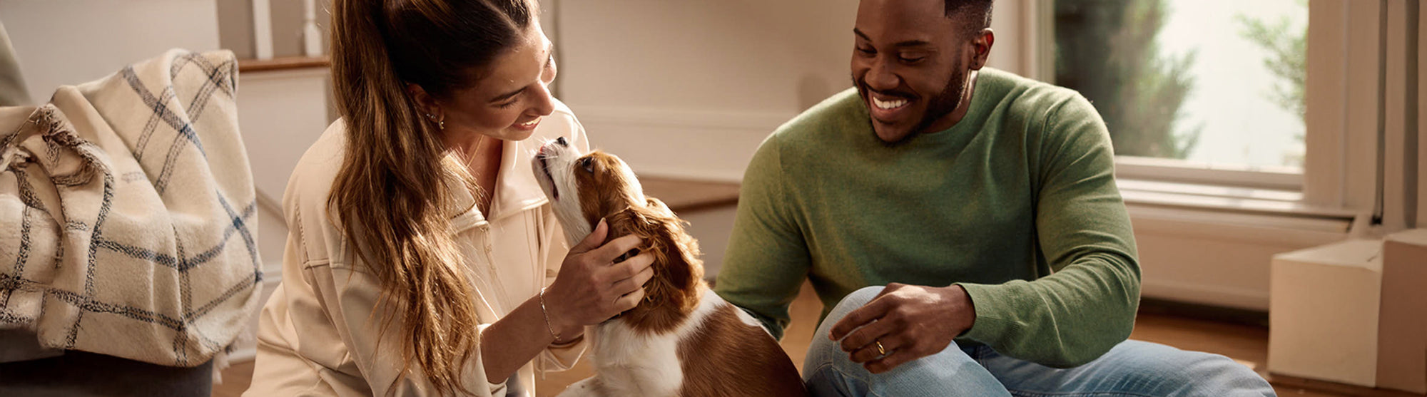 Man and Woman playing with a white and brown puppy