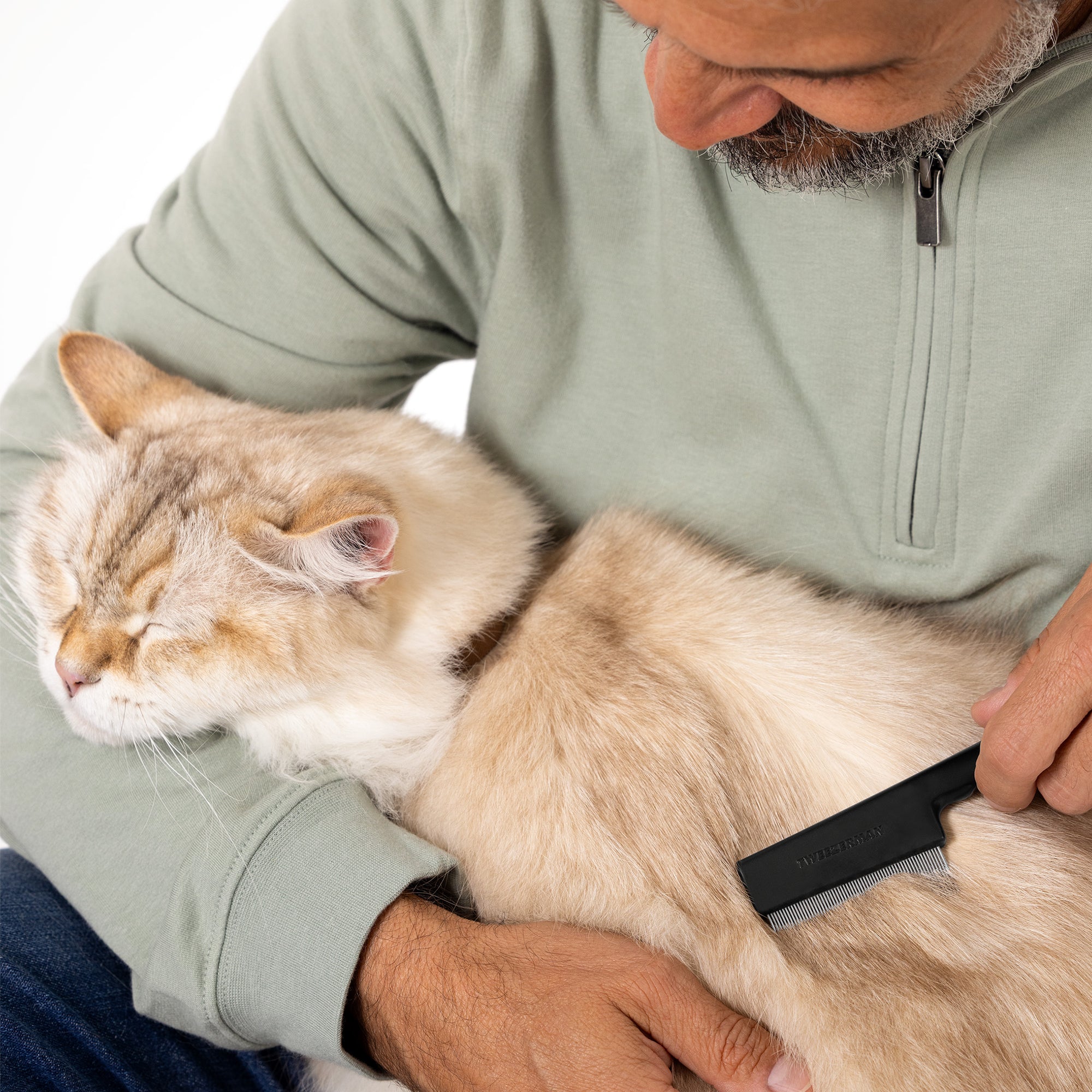 Model holding Cat and combing with Pet Precision Single Row Flea Comb