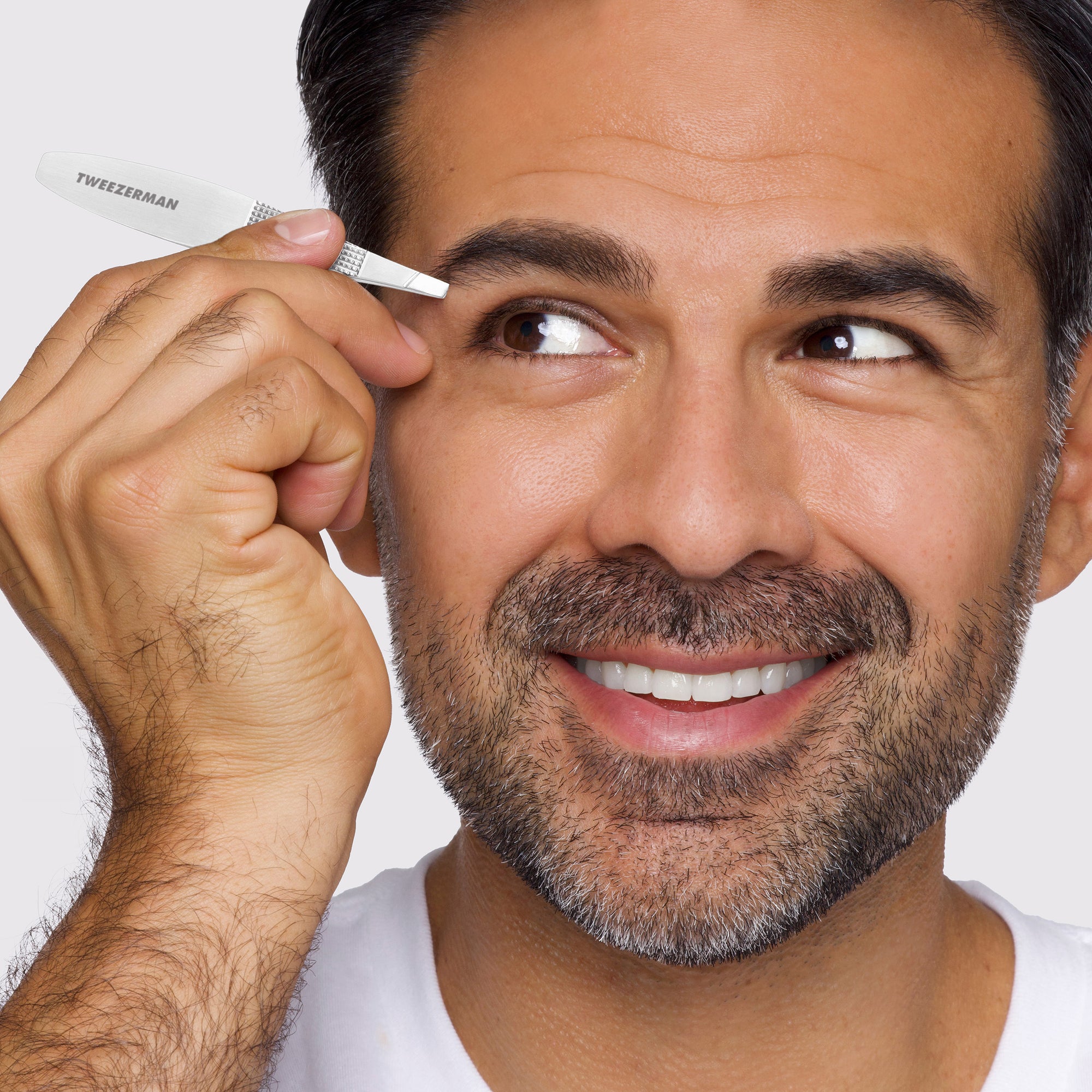 Male Model using the Wide Grip Slant Tweezer to tweeze brows