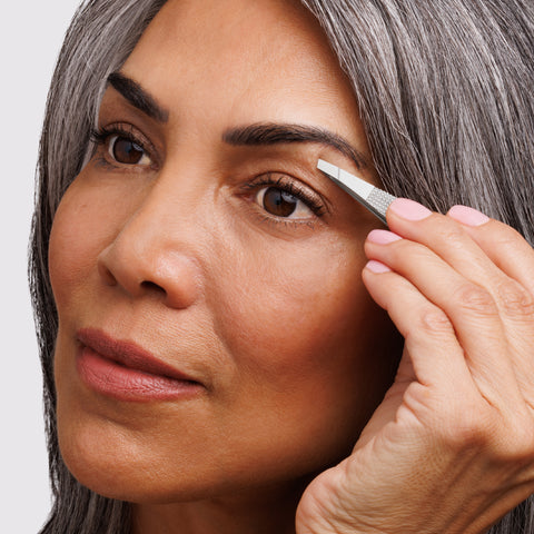 Female Model using the Wide Grip Slant Tweezer to tweeze brows