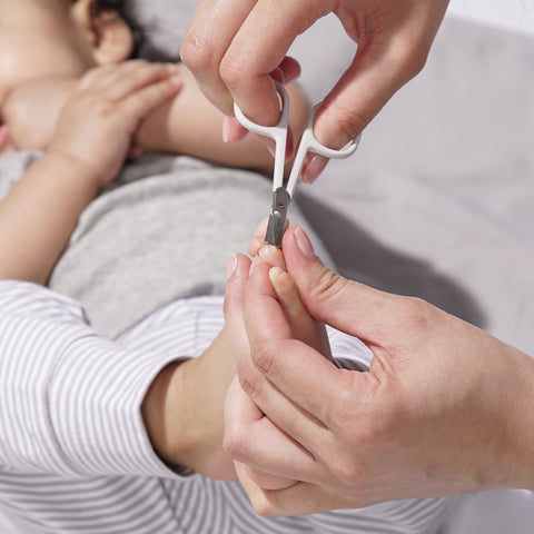 Model using Green Baby nail scissors on baby's feet