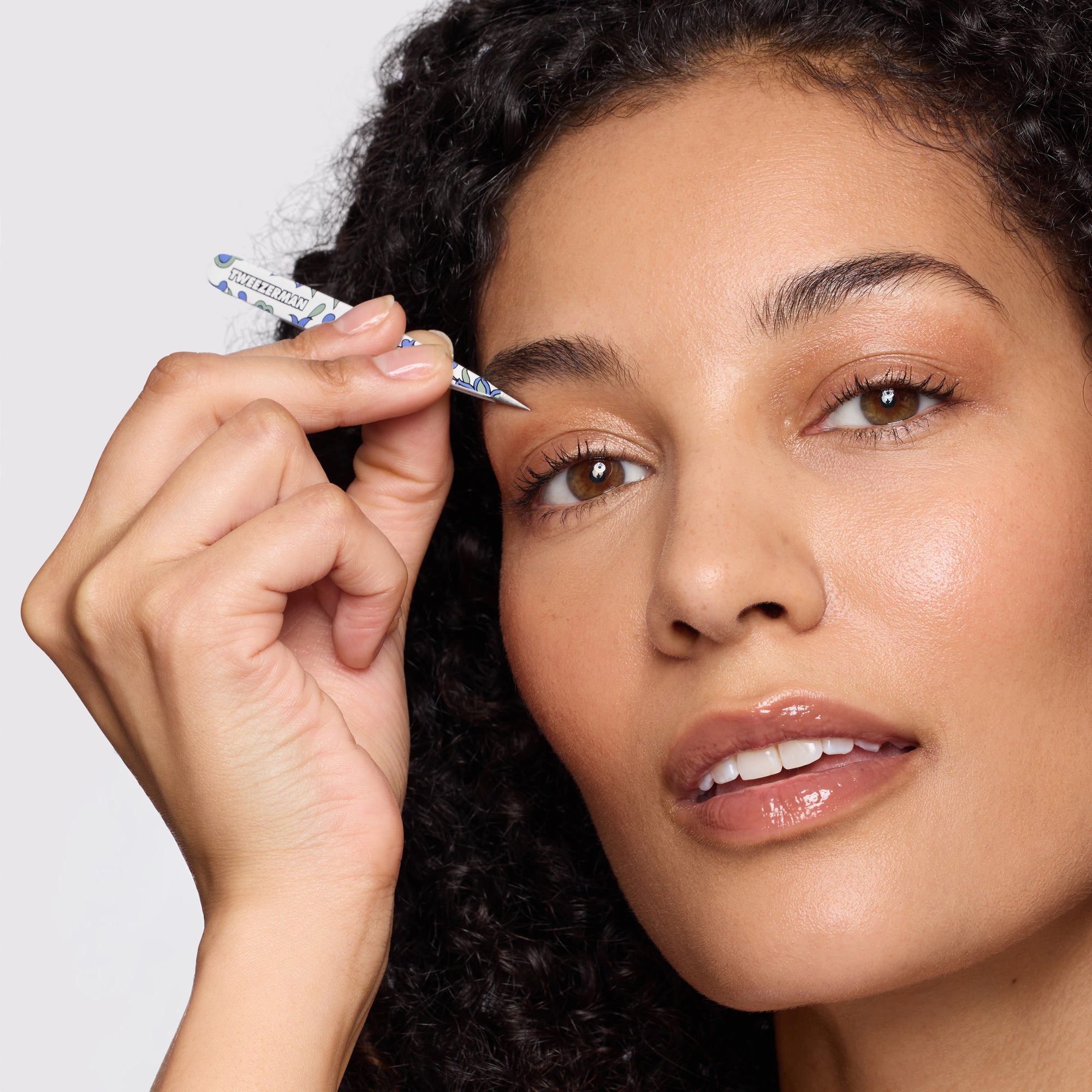 Female model using the point tweezer from the Paisley Petite Tweezer Set