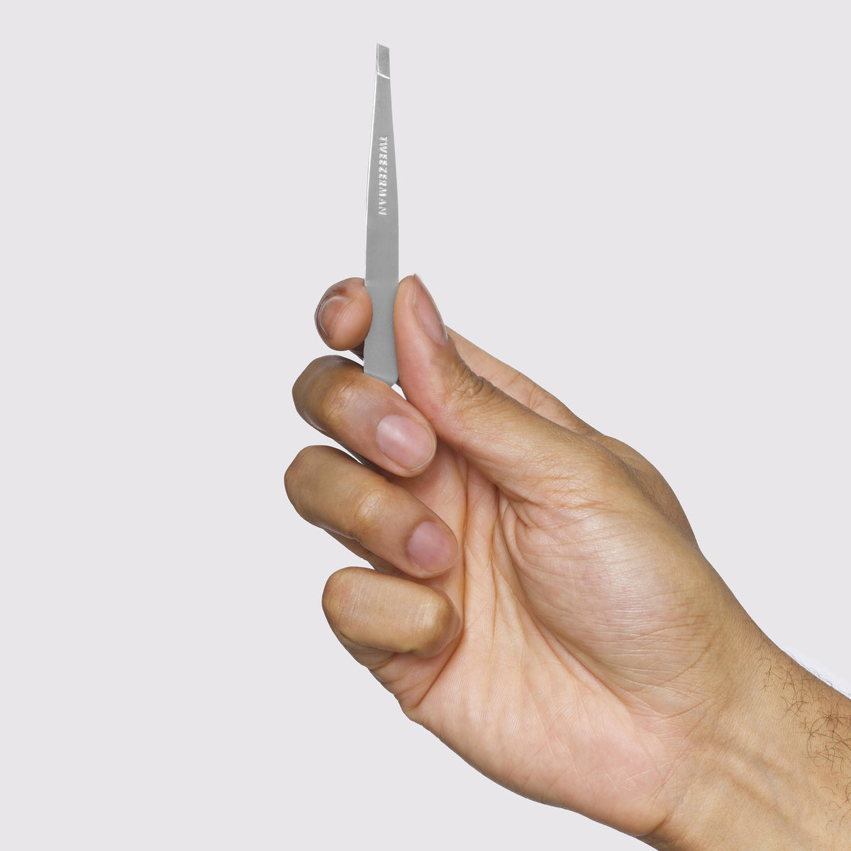 Hand holding the Tweezerman Classic Slant Tweezer upright