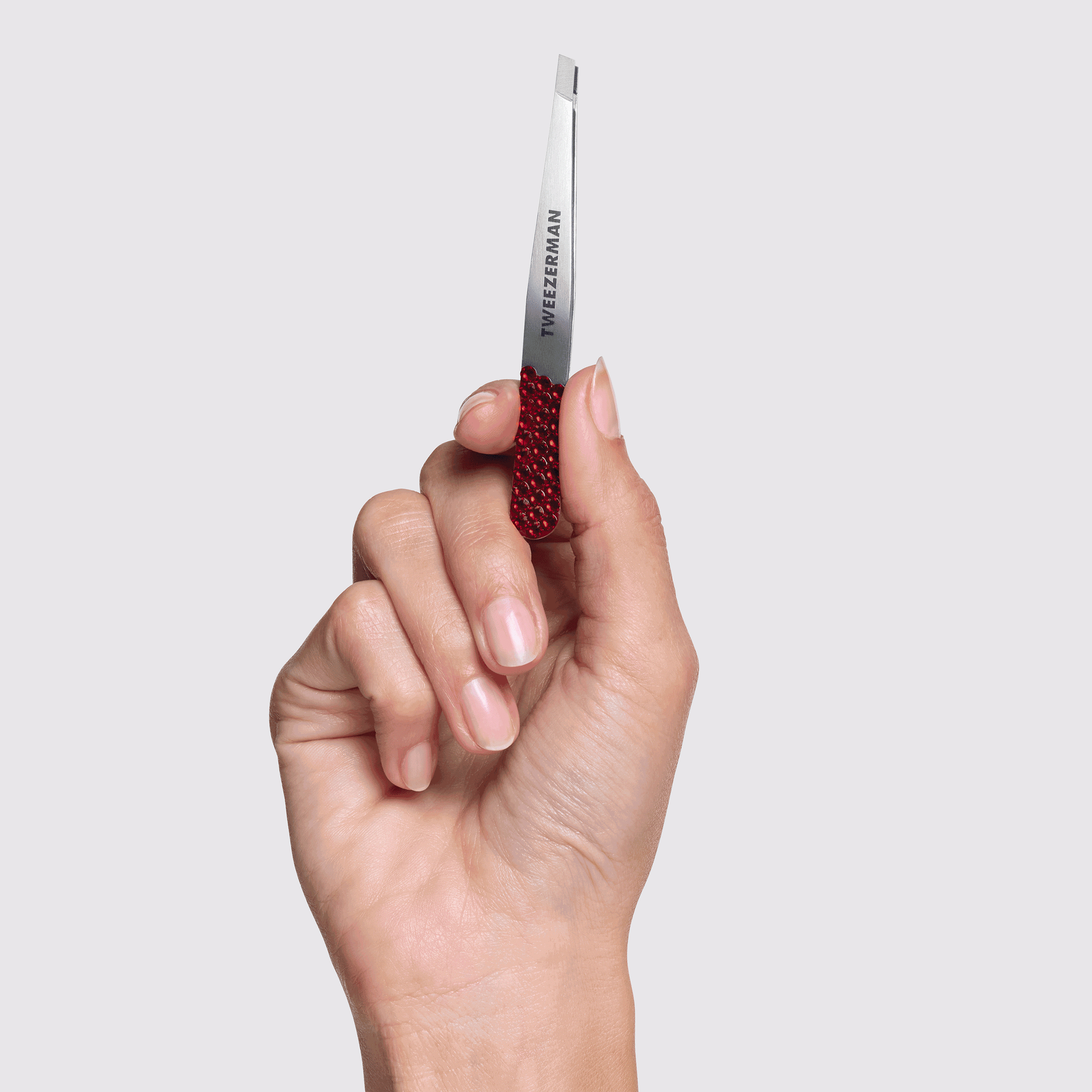 Animated image of Model holding The Devil Wears Prada 2 Crystal Slant Tweezer with and without its case