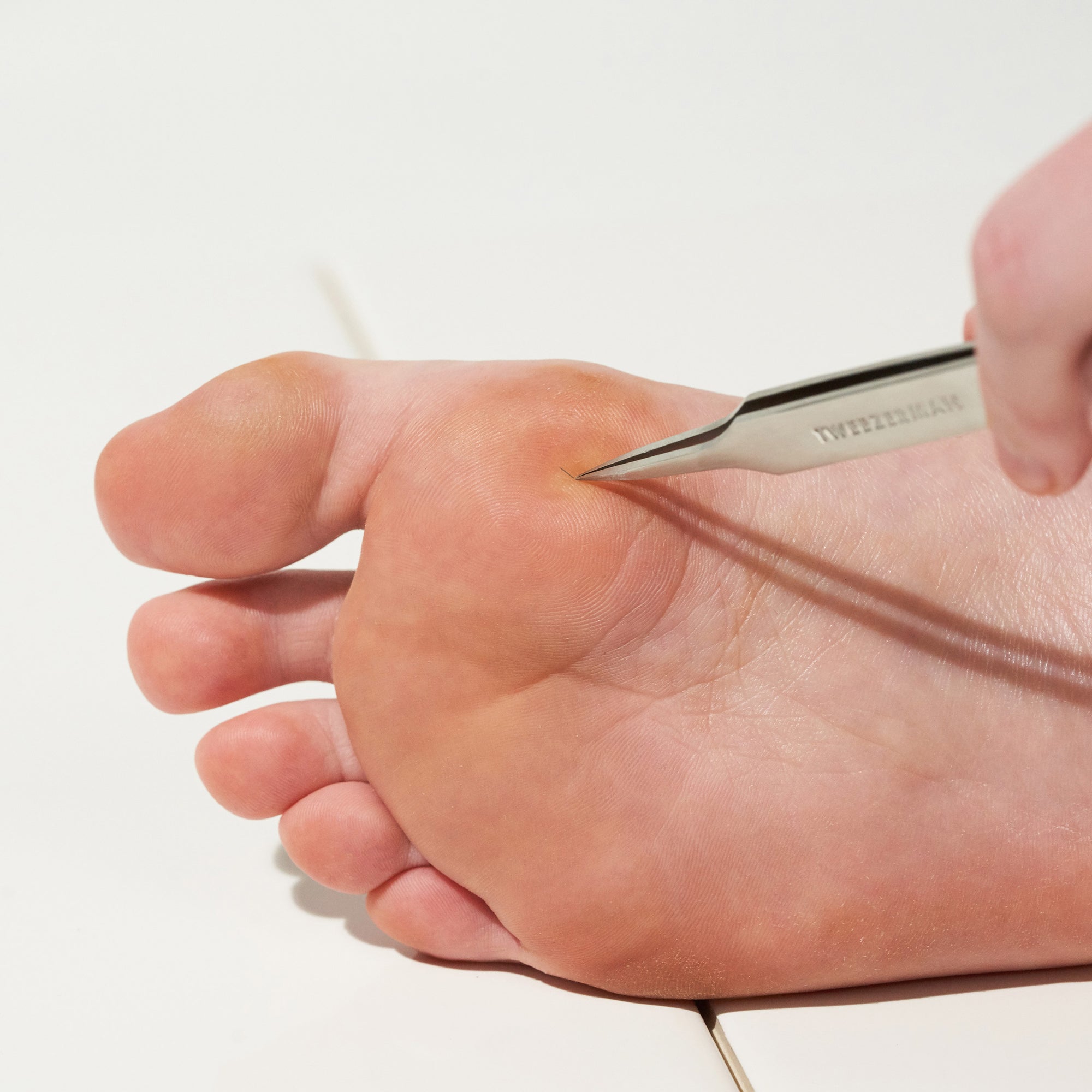 Male Model using Splintertweezer removing splinter on foot