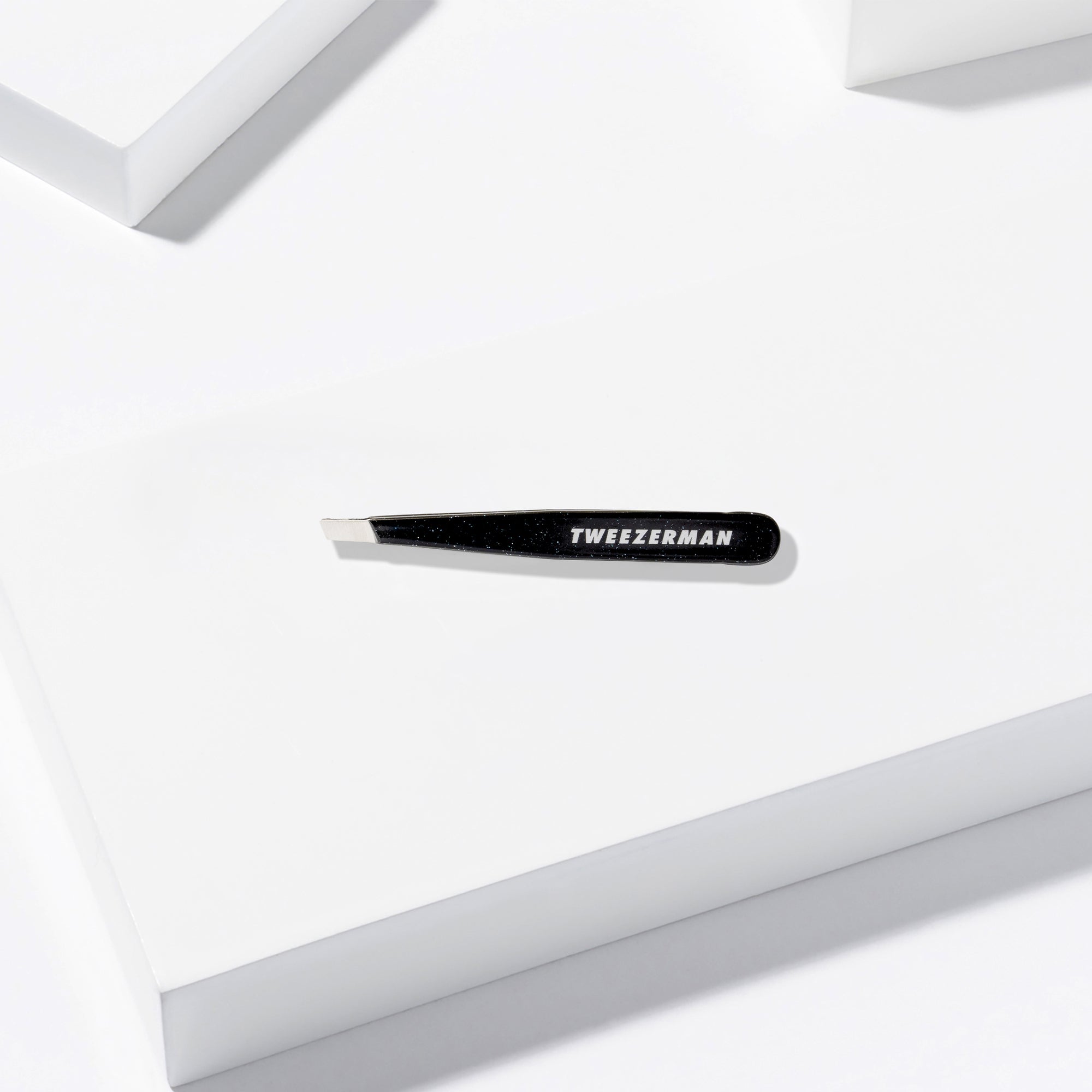 Dusted Onyx Mini Slant Tweezer placed on a white background
