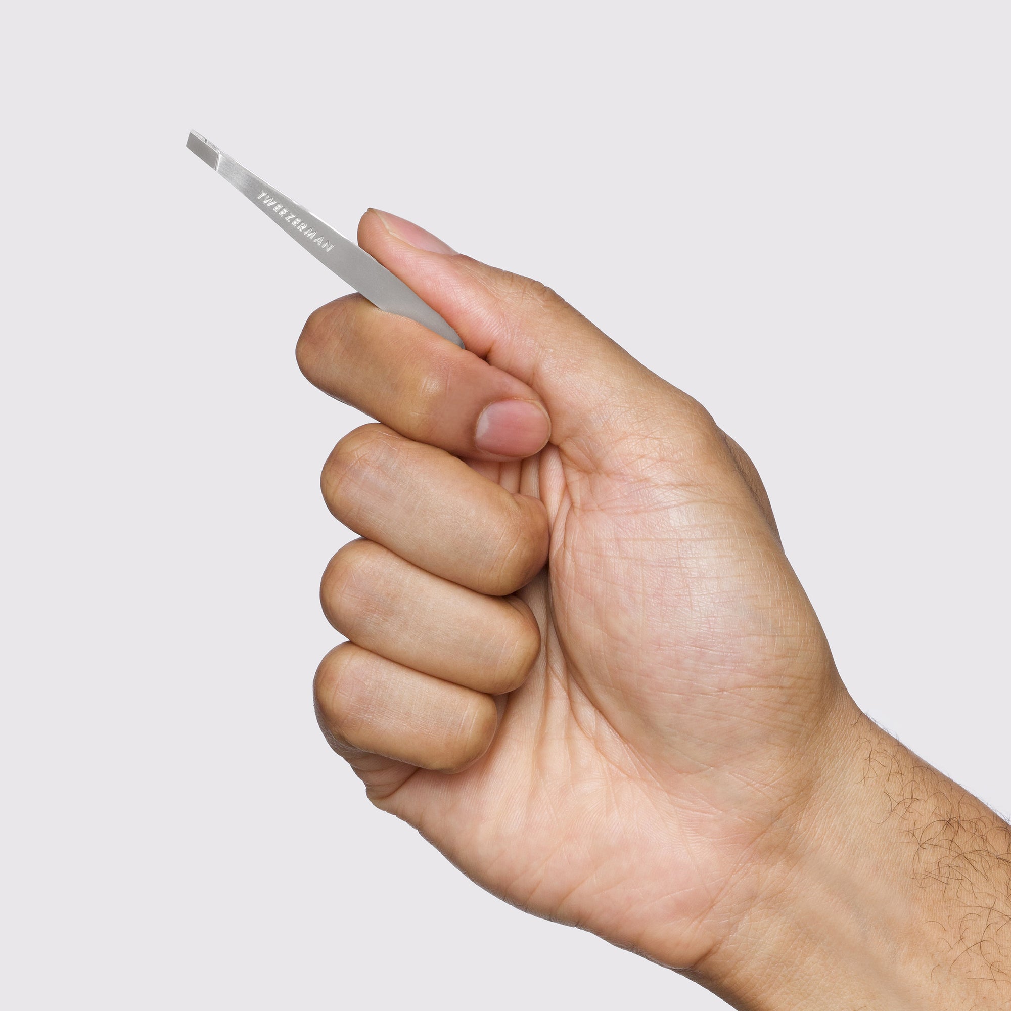 Male Model holding classic mini slant tweezer 