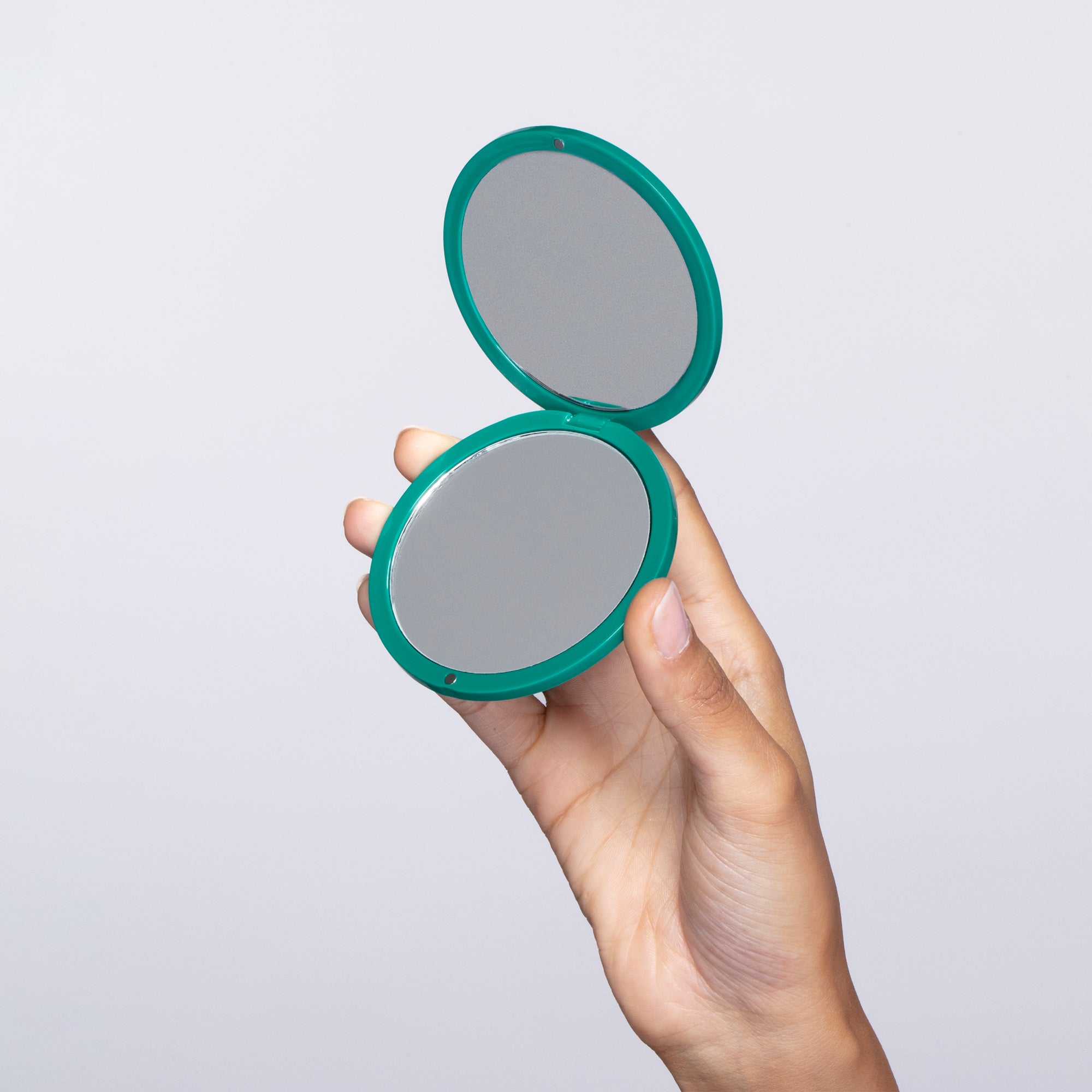Hand holding Emerald Shimmer Mirror.