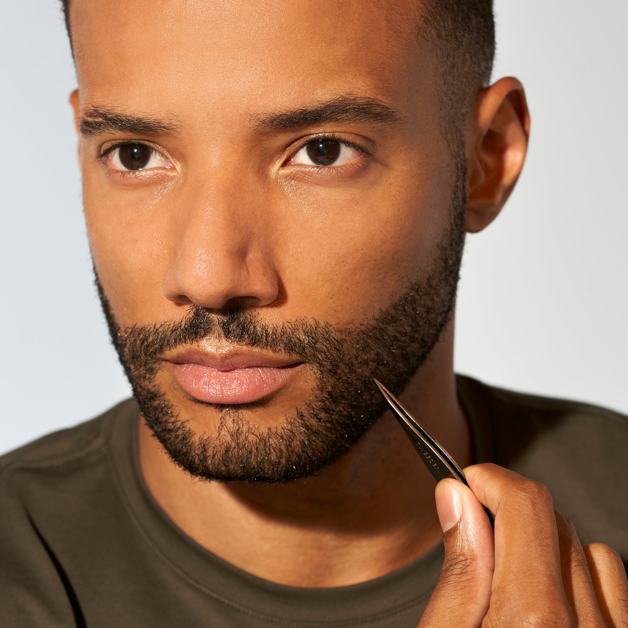 Male model using Mens Metallic Black point tip tweezer with fish body