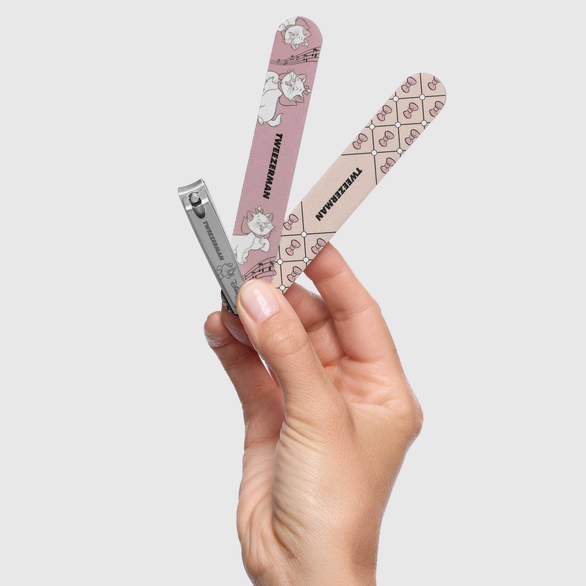 Model holding Disney&#39;s The Aristocats Nail Files and Disney&#39;s Ear-esistible Fingernail Clipper
