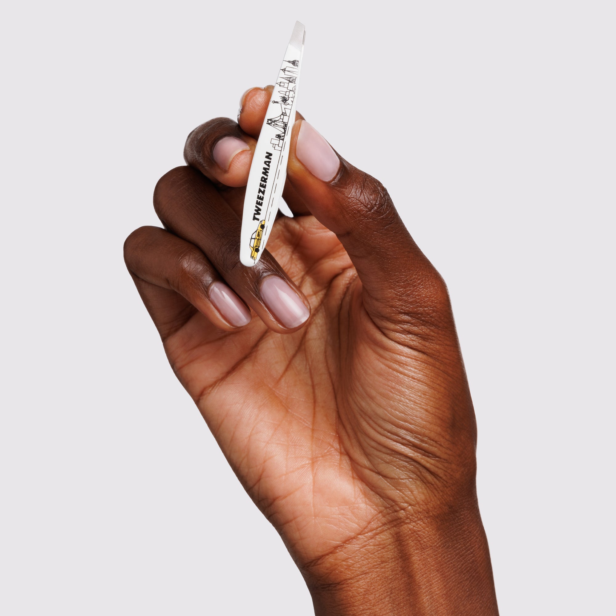 Model holding the NYC Mini Slant Tweezer