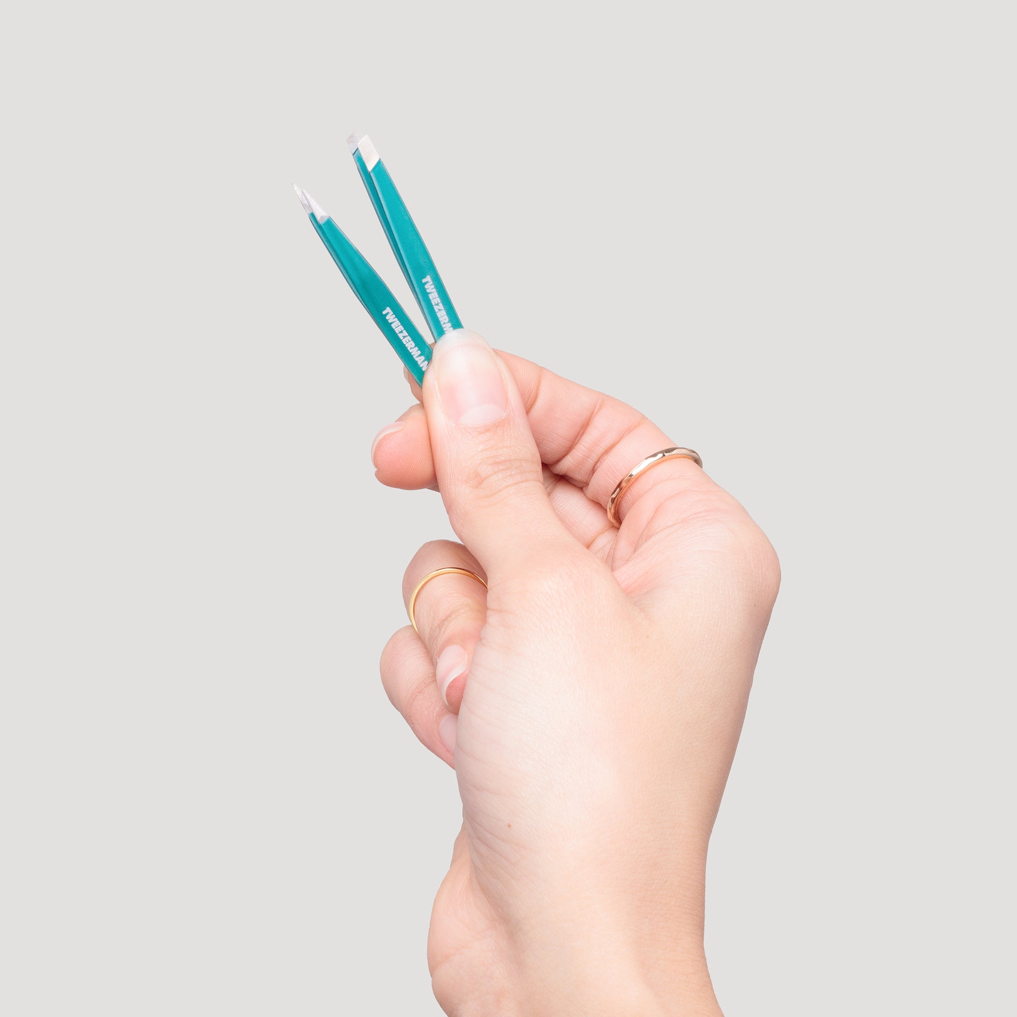 Model holding Majestic Turquoise Micro Mini Slant Tweezer and Point Tweezer
