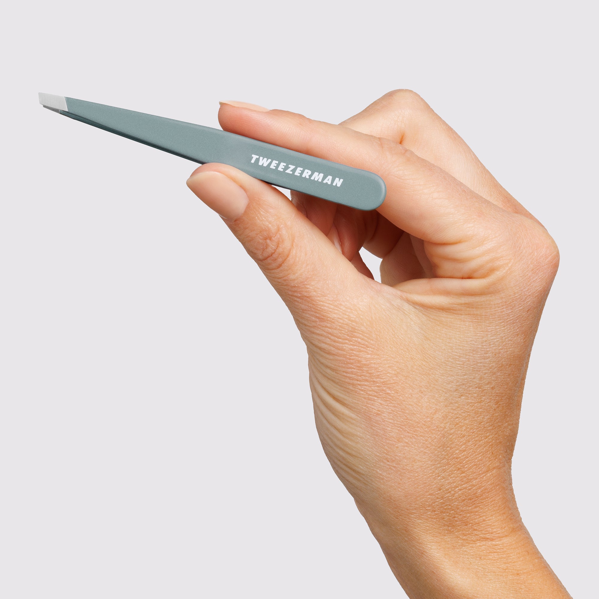 Female Model holding the Mist Blue Slant Tweezer