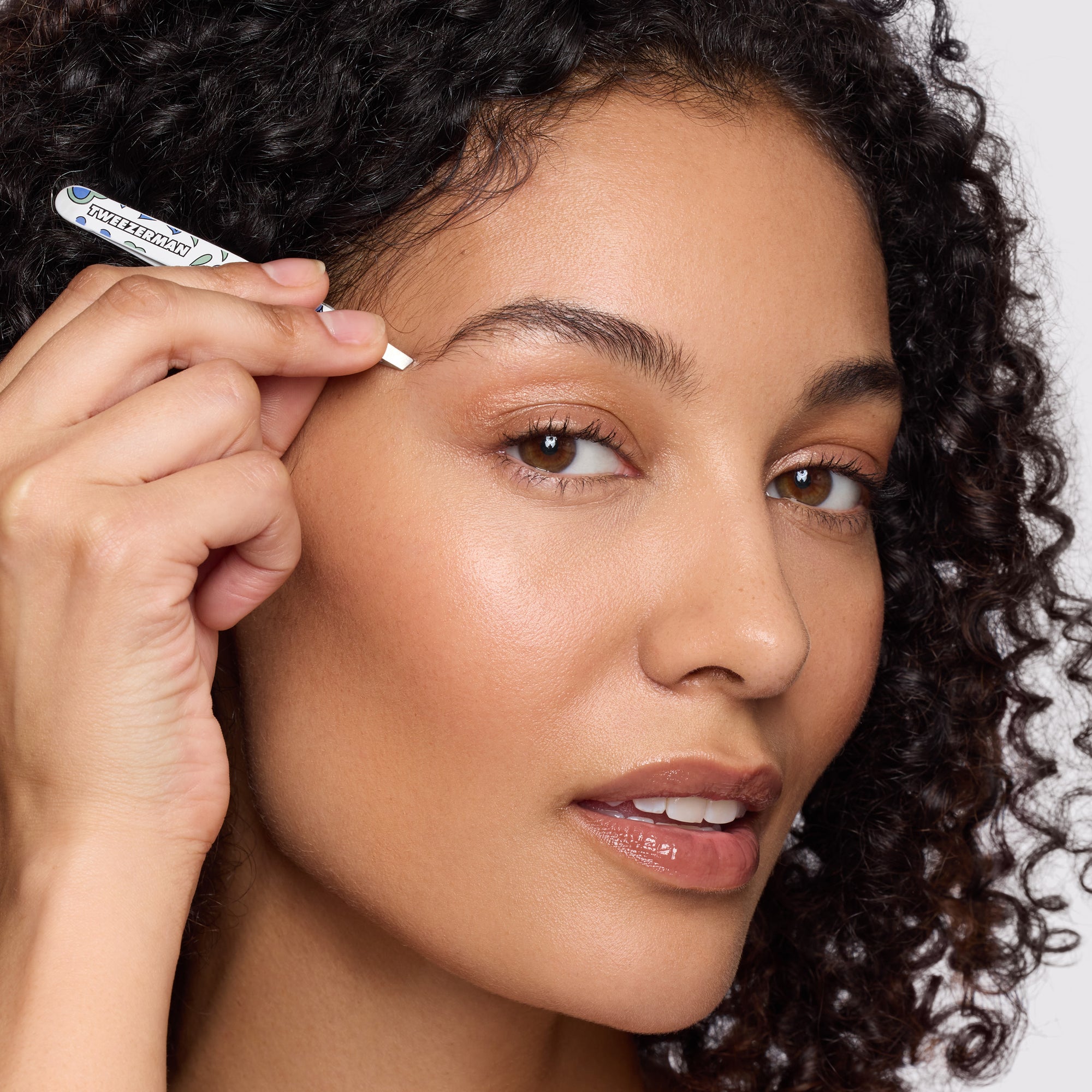 Female model using the slant tweezer from the Paisley Petite Tweezer Set