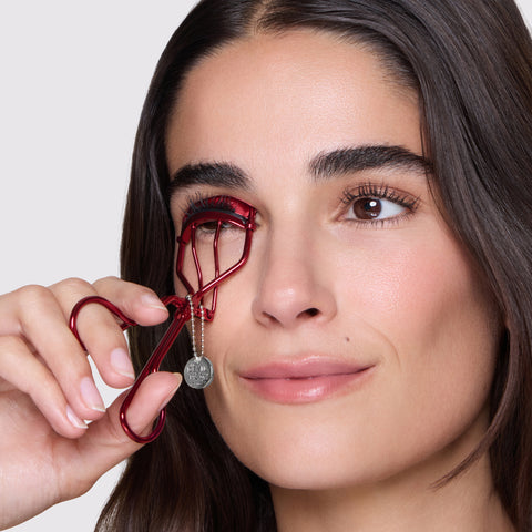 Model curling her eyelashes with The Devil Wears Prada 2 Curler