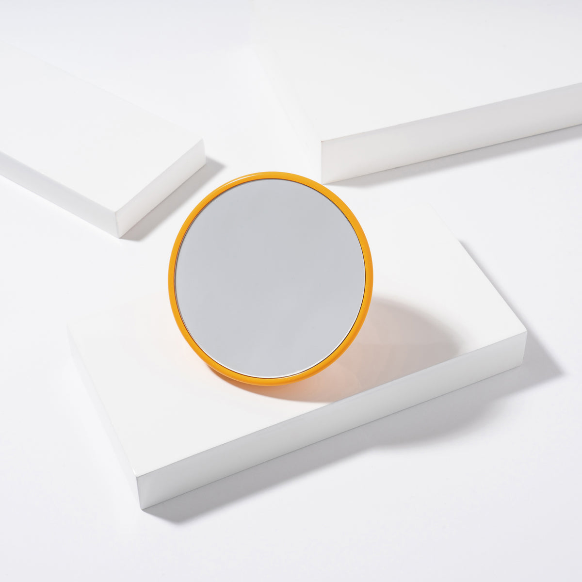Orange Mirror with suction placed on a white block tray